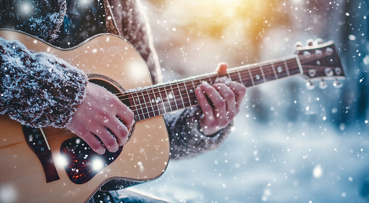 Man playing guitar during snowfall